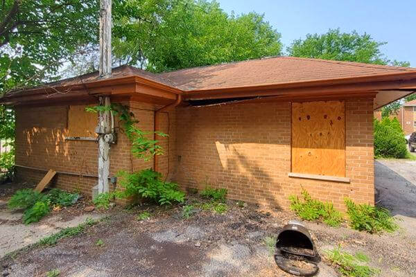 Boarded Up vandalized inherited house in Maywood sold as-is